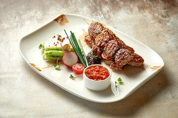 Pork shish kebab with salad and sauce. Close-up selective focus. Grilled meat