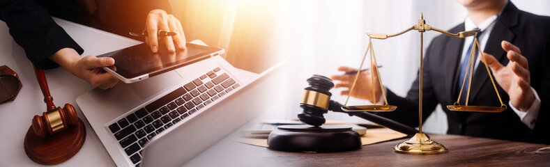 Justice and law concept.Male judge in a courtroom with the gavel, working with, computer and docking keyboard, eyeglasses, on table in morning light