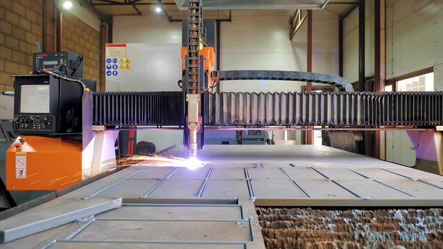 Industrial plasma cutter cuts a part on a metal plate