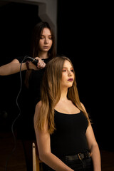 Obraz na płótnie Canvas Beautiful, brunette hair girl with long hair and her hairdresser in a beauty salon. Professional hair care and creating hairstyles.