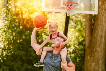 Fotobehang Gelukkige vader en kinddochter buiten bij basketbalhof. © Louis-Photo