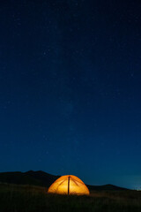 Starry sky above a tourist tent in the mountains.