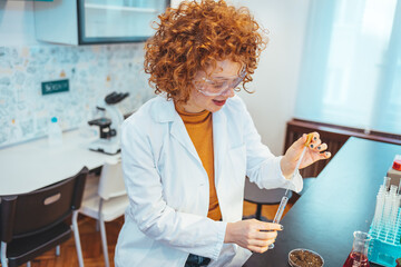 Modern laboratory interior. Woman working on medical samples in background. Young female scientist standing in her lab. Young Female Scientist Working in The Laboratory