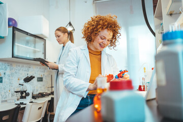 Modern laboratory interior. Woman working on medical samples in background. Young female scientist standing in her lab. Young Female Scientist Working in The Laboratory