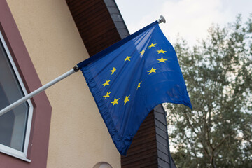 Flying EU flag on the building wall EU flag fluttering in the wind close-up