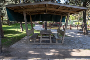 Plakat Picnic shelter or Covered picnic table in public park. Wooden eating bench.