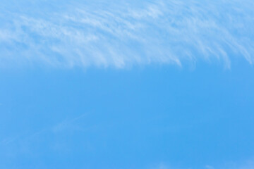 Clear blank blue sky with small translucent white clouds natural background