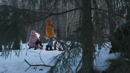 Two children with flashlight torch lost in snowy forest at night, pan right