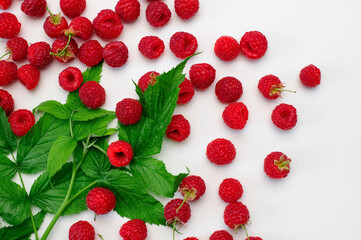 Ripe juicy fresh raspberries with green leaf on white background flat lay top view. Raspberry pattern. Organic raspberries, healthy food, vitamins, summer berry fruit background. Raspberry harvest