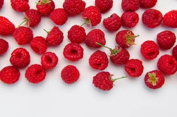 Ripe juicy fresh raspberries on white background flat lay top view. Raspberry pattern. Organic raspberries, healthy food, vitamins, summer berry fruit background. Raspberry harvest