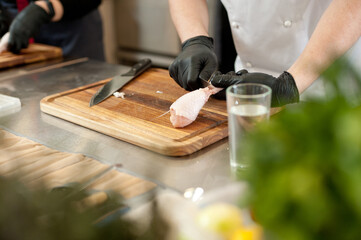 Cook preparing chicken confit leg.