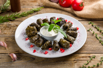 Dolma with sour cream on white plate georgian kitchen on old wooden table