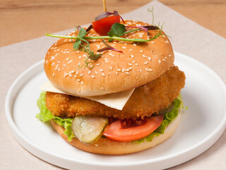 burger with breaded chicken fillet cheese and vegetables