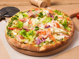 pizza with salmon, tomatoes, salad mix and green butter