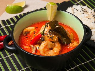 tom yam with seafood garnished with lime and hot pepper