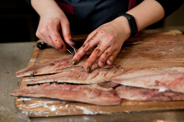 The cook separates the fillet from the fish and clears it from the bones. Mackerel fillets.