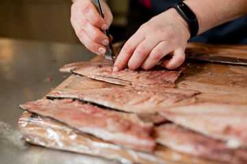 The cook separates the fillet from the fish and clears it from the bones. Mackerel fillets.