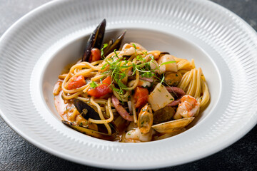 Pasta spaghetti with seafood on a white plate, mussels, shrimps, octopus,squid