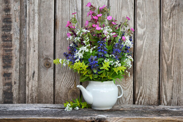Bouquet of colorful wildflowers on an old wooden background. Still life with wild flowers