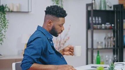 Black young man opening laptop and starting work on project, freelance job