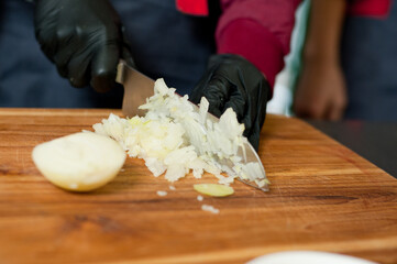 The cook cuts vegetables with a knife to prepare the dish. Cutting vegetables.