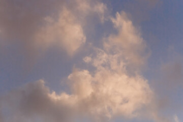 Fototapeta na wymiar Soft airy warm yellow sunlight clouds sky blue evening natural background