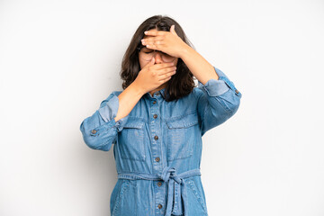 hispanic pretty woman covering face with both hands saying no to the camera! refusing pictures or...
