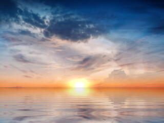 Naklejka na ściany i meble blue bright sky with sun flares on yellow cloudy sunset sun beam light at sea water reflection nature background 