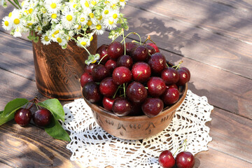 Fototapeta na wymiar sweet cherries on wooden table in the garden