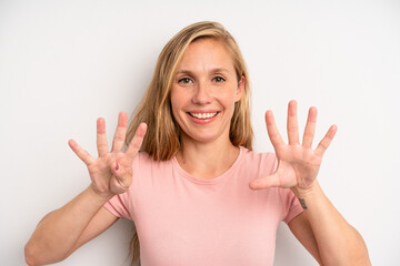 blonde pretty woman smiling and looking friendly, showing number nine or ninth with hand forward,...