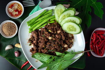 Thai Spicy minced beef meat. Food in the southeast of Thailand or Isan. ''Laab beef''with cucumber slices top view.