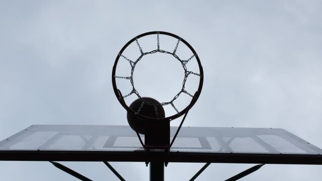 Basketball flies into basket by ricocheting off the shield. Closeup bottom view