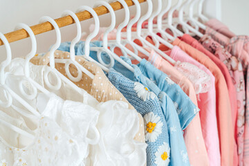 Clothing Rack with children's outfits close up. Home kids wardrobe. Nursery Storage Ideas. Baby...