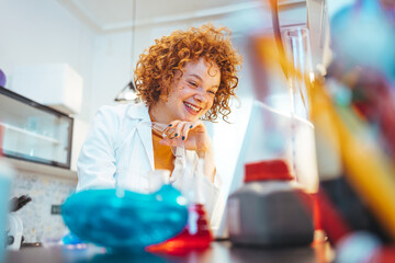 Scientist looking at test tube in the laboratory at the university. Laboratory assistant analyzing a sample. Scientist / researcher team conducting scientific research in science lab.