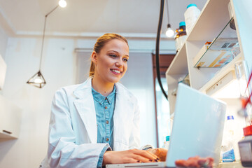 Shot of a female scientist working in a lab. Close-up of serious laboratory worker holding ampoule...