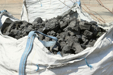 Coal in a big bag.Close-up of a fossil fuel ready for a furnace. selective focus