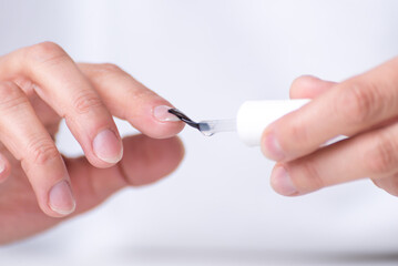  adult woman's hands painting her nails, drop about to fall, nail clippers, nail polish remover, manicure at home, personal health and beauty