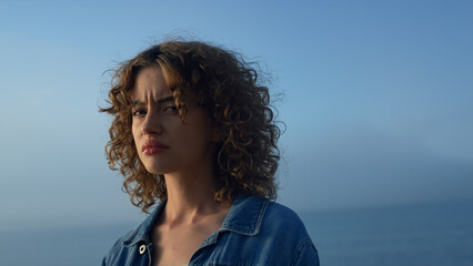 Thoughtful woman looking ocean horizon. Stylish girl feeling loneliness