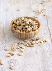 Bowl of raw dry Grass pea close up on wooden table. Legumes known in Italy as Cicerchia