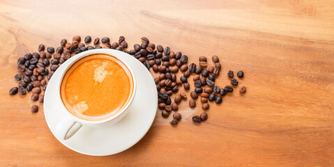 Top view of coffee cup has golden foam and mixed or blend coffee beans  on wooden backgrou