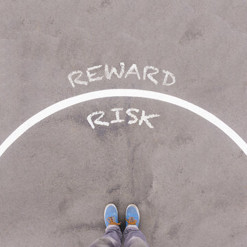 Risk and Reward, text on asphalt ground, feet and shoes on floor