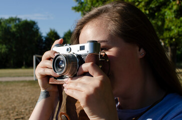 Young woman taking picture with an old/vintage film camera	