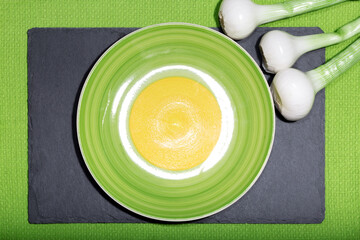 Green onions and an empty plate on a cutting board. Leek with bulbs. Healthy food concept