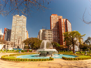Central panorama of the city of Belo Horizonte. Raul Soares Square. Trees, fountain, blue sky and beautiful residential and commercial buildings.