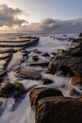 High tide ocean water flowing around rocks.