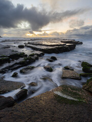 High tide ocean water flowing around rocks.