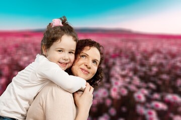 Fototapeta premium Tender mother and daughter happy together, hugging in nature in a field on a summer day