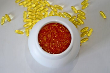 A jar of Omega-3 capsules, top view, capsules are also scattered around the jar. Food supplement, vitamins, healthy lifestyle, medicine, nutrition