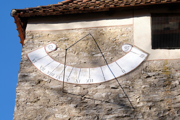 Close-up of the sundial on the wall of an old chapel on the Moritzberg in Germany on a sunny february day. - obrazy, fototapety, plakaty