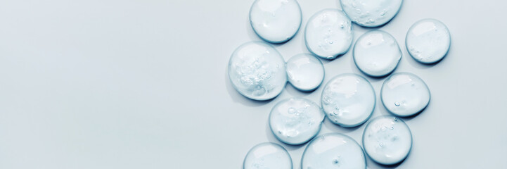 Liquid gel abstract cosmetic swatch drops on blue banner. Smear of transparent moisturizing product